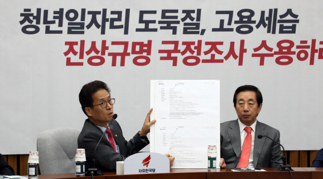 함진규(왼쪽) 자유한국당 정책위의장이 23일 국감대책회의에서 관련 자료를 들어보이고 있다. /연합뉴스