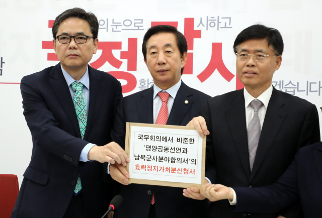 김성태(가운데) 자유한국당 원내대표가 24일 국회 원내대표회의실에서 곽상도(왼쪽), 최교일 의원과 함께 긴급 기자회견을 하며 ‘국무회의에서 비준한 평양공동선언과 남북군사합의서의 효력정지가처분 신청서’를 들어 보이고 있다. /연합뉴스