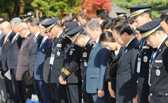 문재인 대통령이 25일 오후 서울 용산구 백범기념관에서 열린 제73주년 경찰의 날 기념식에서 참석자들과 순직 경찰관에 대해 묵념을 하고 있다. /연합뉴스