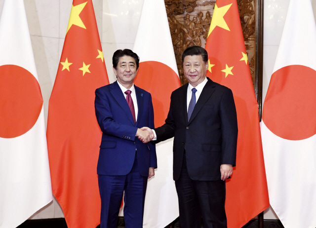 시진핑(오른쪽) 중국 국가 주석과 아베 신조 일본 총리가 26일 베이징 댜오위타이 영빈관에서 정상회담을 하기 앞서 악수를 하고 있다. /베이징=교도연합뉴스