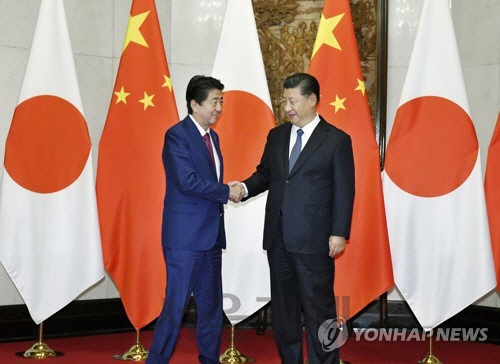 시진핑(오른쪽) 중국 국가주석이 26일 베이징에서 아베 신조 일본 총리와 만나 악수를 하고 있다. /연합뉴스
