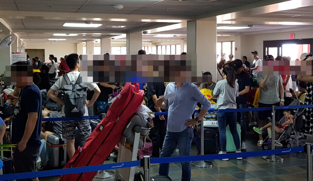 28일 오전 슈퍼 태풍 ‘위투’가 지나간 사이판 공항 아시아나항공 카운터에서 여행객들이 출국 수속을 기다리고 있다. /연합뉴스