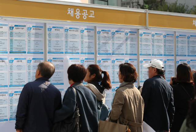 지난 24일 서울 강동구청에서 열린 2018 강동 취업박람회에서 구직자들이 채용공고를 살피고 있다./연합뉴스