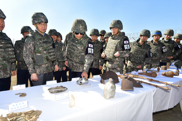 남북공동선언 이행추진위원장인 임종석 대통령 비서실장 및 위원들이 17일 오후 남북공동유해발굴을 위한 지뢰제거 작업이 진행 중인 강원도 철원군 육군 5사단 비무장지대 GP를 방문, 발굴 현장에서 나온 물품들을 살펴보고 있다. /연합뉴스