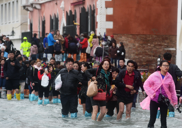 이탈리아 북부를 강타한 폭우로 조수가 해수면 위 156㎝까지 급상승하면서 물바다가 된 베네치아에서 29일(현지시간) 관광객들이 물속을 걸어다니고 있다. /로마=AFP연합뉴스