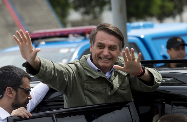 28일(현지시간) 브라질 대선 결선투표에서 차기 대통령에 당선된 극우 성향의 자이르 보우소나루 후보가 리우데자네이루에서 투표를 마친 후 지지자들에게 손을 흔들고 있다. /리우데자네이루=AP연합뉴스