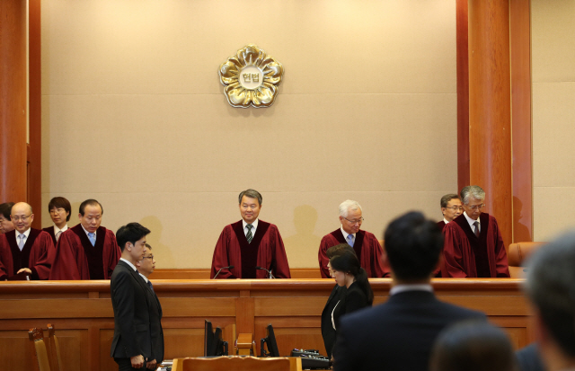 ‘양심적 병역거부’ 판결 위해 이진성 헌법재판소장을 비롯한 헌법재판관들이 28일 오후 서울 종로구 헌법재판소 대심판정에 입장하고 있다./연합뉴스