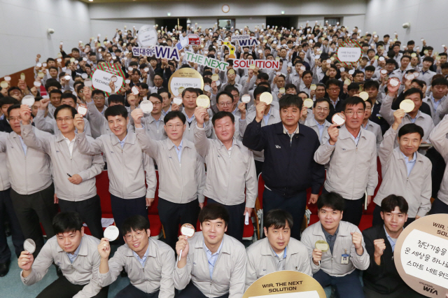 김경배(두번째 줄 오른쪽에서 네번째) 사장을 비롯한 현대위아 임직원들이 1일 경남 창원에 위치한 본사에서 가진 새 비전 결의 대회에서 비전 카드를 들어보이면서 기념 촬영을 하고 있다. /사진제공=현대위아