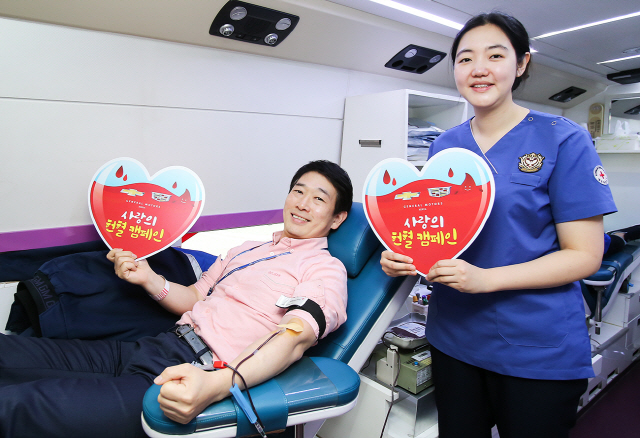 지난 1일 한국GM이 인천 부평 본사 및 청라 주행시험장에서 대한적십자사와 함께 연 ‘사랑의 헌혈 캠페인’에 참여한 직원(왼쪽)이 헌혈 피켓을 들어 보이고 있다. 이날 한국GM 임직원 150여명이 헌혈에 참여했다. /사진제공=한국GM