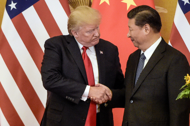 도널드 트럼프 미국 대통령(왼쪽)과 시진핑 중국 국가주석이 지난해 11월 중국 베이징에서 만나 악수를 나누고 있다. 트럼프 대통령은 1일(현지시간) 트위터에 올린 글에서 시진핑 국가주석과 전화통화를 하고 미 중간 마찰을 빚고 있는 무역문제와 함께 북한에 대해서도 논의했다고 전했다./AFP연합뉴스