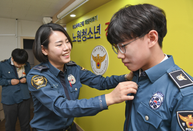 서울 노원경찰서의 학교전담경찰관(SPO)인 황수지 순경이 지난달 31일 서울 공릉2치안센터에서 학교폭력 예방교육의 일환으로 개최한 청소년경찰학교에서 참여 학생에게 경찰 제복을 입는 방법을 알려주고 있다. /송은석기자