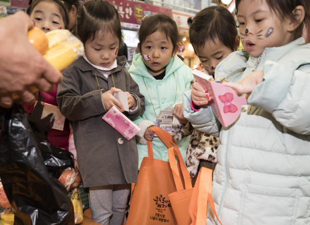 지난달 31일 오전 서울 광진구 중곡제일전통시장에서 열린 ‘전통시장 비닐봉투 FREE DAY’행사에서 어린이집 원아들이 전통시장 장보기 체험을 하고 있다. /연합뉴스