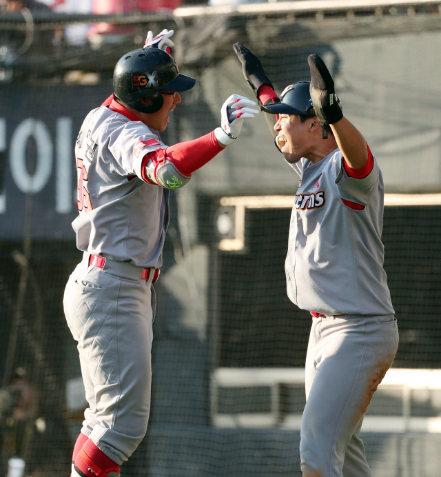 SK 박정권(왼쪽)이 4일 서울 잠실구장에서 열린 두산과의 2018 KBO 한국시리즈 1차전 6회초 공격에서 역전 결승 투런 홈런을 터뜨린 뒤 선제 투런포의 주인공 한동민과 함께 환호하고 있다. /연합뉴스