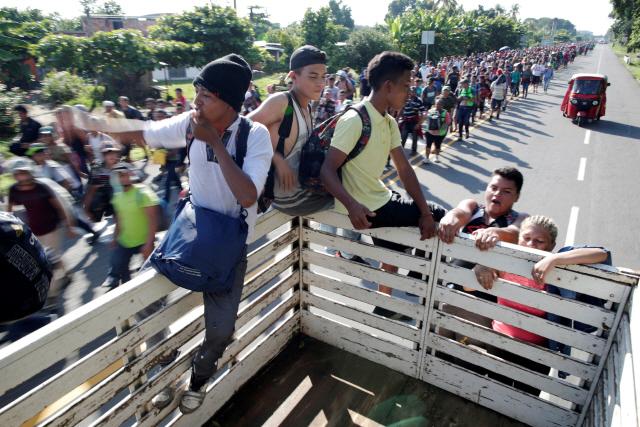 미국으로 향하는 중미 출신 젊은이들이 지난 달 21일(현지시간) 트럭에 매달린 채 멕시코·과테말라 국경 고속도로를 지나고 있다./타파출라=로이터연합뉴스