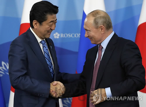 블라디미르 푸틴 러시아 대통령(오른쪽)과 아베 신조 일본 총리가 악수하는 모습. /AP연합뉴스