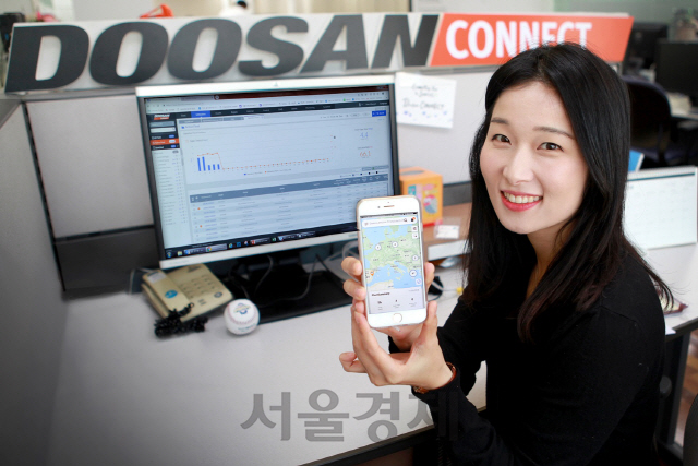 두산인프라코어 관계자가 두산커넥트 모바일 앱 화면을 보여주고 있다./사진제공=두산인프라코어