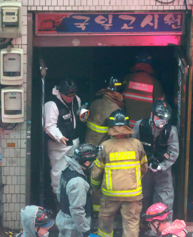 9일 오전 화재가 발생한 서울 종로구 관수동의 국일고시원에서 경찰, 소방대원들이 고시원 입구를 오가고 있다. /연합뉴스