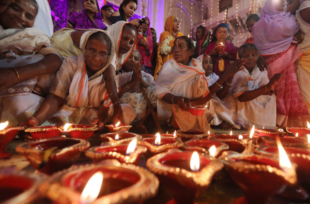 4일(현지시간) 인도 북부 우타르프라데시주 서쪽 끝에 있는 힌두교의 성징 브린다반에서 여성들이 디왈리 축제를 기리는 촛불을 붙이고 있다. /브린다반=EPA연합뉴스