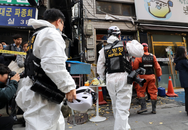 9일 발생한 서울 종로구 고시원 화재를 조사하기 위해 경찰과 소방 관계자들이 10일 현장으로 들어가고 있다. /연합뉴스