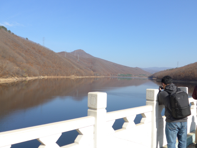 중국 지린성 투먼시의 ‘봉오 저수지’를 찾은 한 방문객이 사진을 촬영하고 있다.