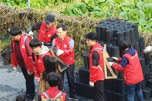 광동제약 모과균(뒷줄 왼쪽 두번째) 사장 등 임직원들이 서울 노원구 백사마을을 찾아 독거노인 등 난방취약 가정에 연탄 나눔 봉사활동을 하고 있다. /사진제공=광동제약