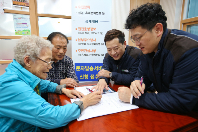 고리원자력본부 직원들이 부산시 기장군 장안읍 구기마을을 찾아 ‘고리본부 SMS알리미’ 신청 접수를 받고 있다./사진제공=고리원자력본부