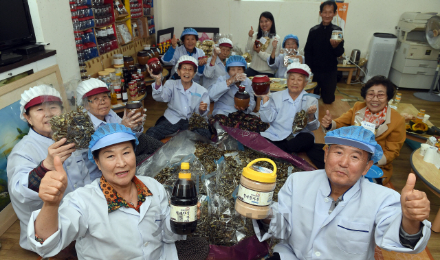 인천 영종도의 마을기업 ‘어머니손맛두레사업’에서 일하는 어르신들이 직접 만든 제품을 들고 ‘우리 제품 최고’를 외치고 있다. /영종도=이호재기자