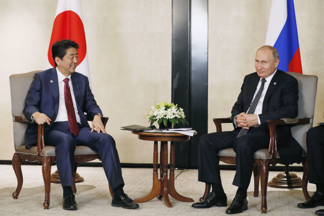 14일 아베 신조 일본 총리(왼쪽)와 블라디미르 푸틴 러시아 대통령이 싱가포르서 정상회담을 하고 있다. /싱가포르=교도연합뉴스