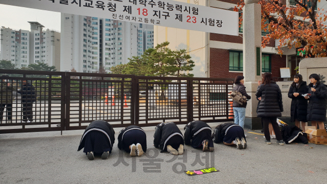 15일 경기여고 재학생들이 수험생을 응원하며 서울 강남구 진선여고 고사장 정문 앞에서 큰절을 올리고 있다. 학생들 앞으로 ‘수능대박’ 문구를 새긴 플래카드가 눈에 띈다./오지현기자