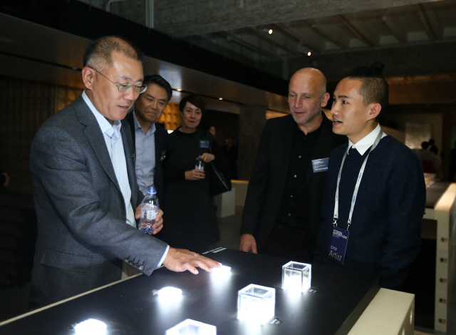 정의선(왼쪽) 현대자동차 수석부회장이 지난 7일 중국 베이징 현대모터스튜디오에서 열린 ‘미래 인류-우리가 공유하는 행성’ 전시회에 참석해 전시 작가인 오지페이(오른쪽)로 부터 작품 설명을 듣고 있다. /사진제공=현대차