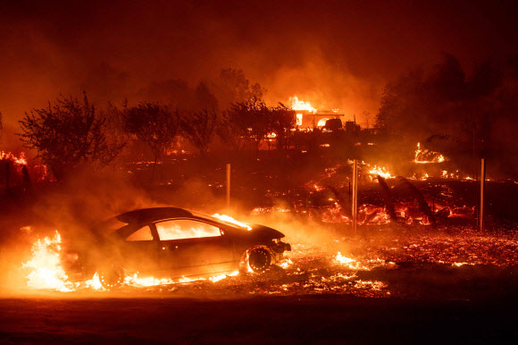 8일(현지시간) 대형산불이 발생한 미국 캘리포니아주 북부 뷰트카운티의 파라다이스 지역에서 차량과 주택들이 화염에 휩싸여 있다. /연합뉴스