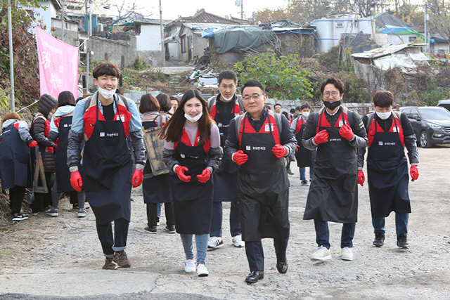 장선욱(앞줄 왼쪽 세번째) 롯데면세점 대표와 임직원 및 협력사원들이 지난 16일 서울 노원구 중계본동 백사마을을 방문해 난방 취약가정에 직접 연탄을 배달하고 있다. 롯데면세점 직원 및 협력사원들은 올해로 11회째를 맞은 ‘샤롯데봉사단 연탄나눔 봉사활동’에서 총 5만장의 연탄과 생필품을 기증했다. /사진제공=롯데면세점