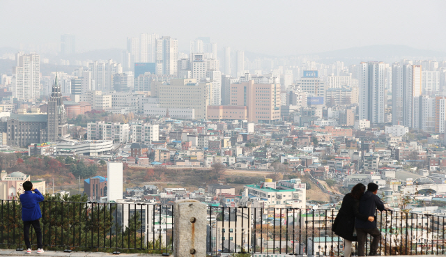 지난 16일 경기도 수원시 서장대에서 시민들이 미세먼지로 뿌옇게 보이는 시내를 바라보고 있다./연합뉴스