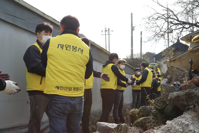 18일 경기도 광주시에서 세진산업개발 위드봉사단이 기초생활수급 가구에 연탄을 전단하고 있다./사진제공=세진산업개발