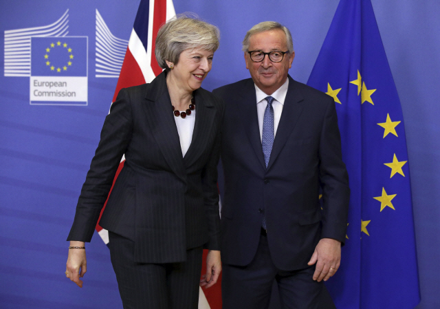 테리사 메이(왼쪽) 영국 총리와 장클로드 융커 유럽연합(EU) 집행위원장이 21일(현지시간) 브뤼셀에서 만나 브렉시트 협상안에 대한 회담을 갖은 뒤 웃으며 이동하고 있다. /브뤼셀=AP연합뉴스