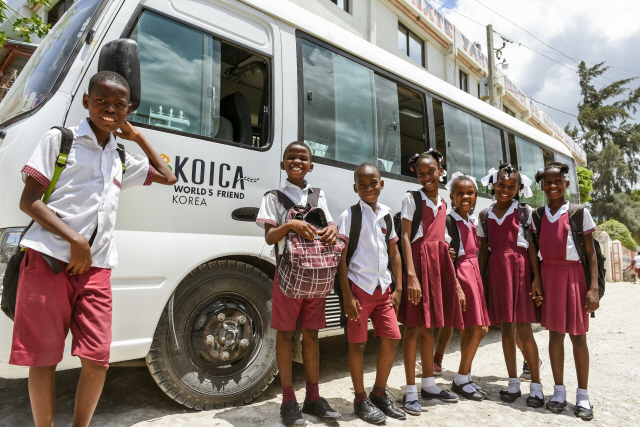아이티 어린이들이 KOICA가 지원한 스쿨버스 앞에서 환하게 웃고 있다. 아이티에는 아직 대중교통 시스템이 제대로 갖춰지지 않아 스쿨버스는 아이들 등하교에 중요하다.         /사진제공=KOICA