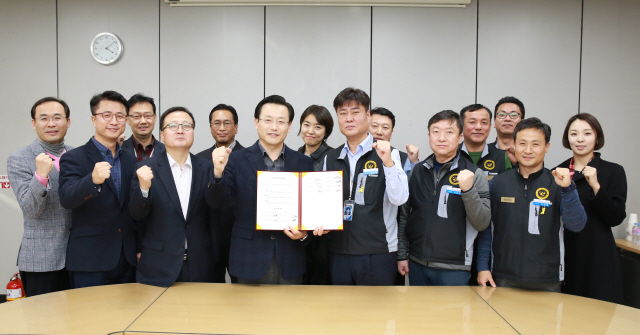 김이배(앞줄 왼쪽 세번째) 아시아나항공 경영관리본부장과 심규덕(〃 네번째) 일반노조 위원장이 22일 서울 강서구 아시아나타운 본사에서 열린 ‘2018 임금교섭’을 완료한 후 직원들과 함께 손을 들어올려 기념촬영을 하고 있다./사진제공=아시나아항공