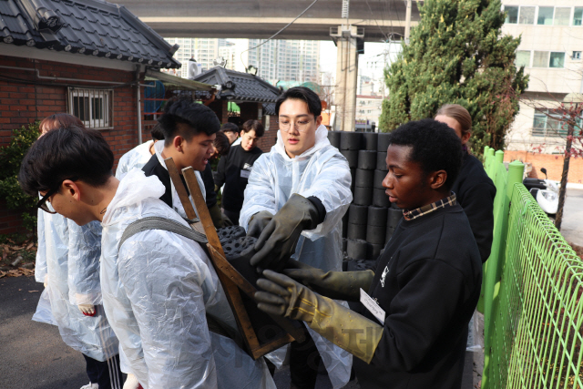 지난 23일 한진그룹과 인하대학교가 인천시 학익동 인하대학교 인근의 소외 계층을 위한 합동 봉사활동을 펼쳤다.   봉사활동에 참여한 인하대학교 학생들이 직접 연탄을 나르고 있다. 이날 행사에는 대한항공, 한진, 한국공항 등 한진그룹 임직원과 인하대학교 관계자, 학생회 등 200여명이 참여해 주민들과 함께 2백여 포기의 김장을 하고 5천여장의 연탄을 나르며 이웃사랑을 실천했다. /사진제공=한진그룹