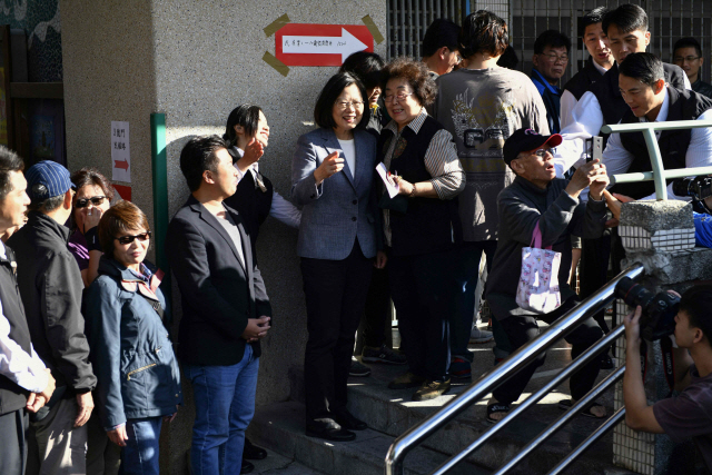 24일 대만의 국민투표가 시작된 가운데 신베이(新北市)시 한 투표소에서 차이잉원(蔡英文, 가운데) 대만 총통이 시민들과 사진을 찍고 있다./타이베이 AFP=연합뉴스연합뉴스