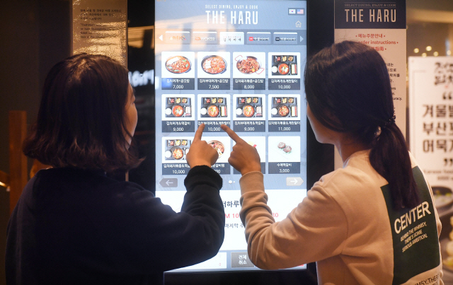 23일 서울의 한 음식점에서 손님들이 자동화기기로 음식을 주문하고 있다./권욱기자