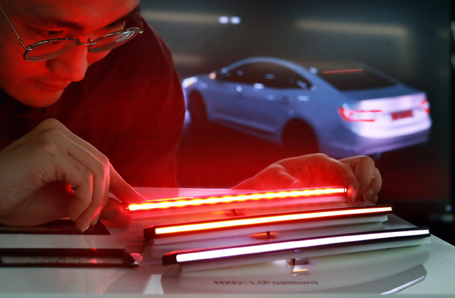 LG이노텍 직원이 26일 차량용 초슬림 라인조명모듈 ‘넥슬라이드-L’을 살펴보고 있다. /사진제공=LG이노텍