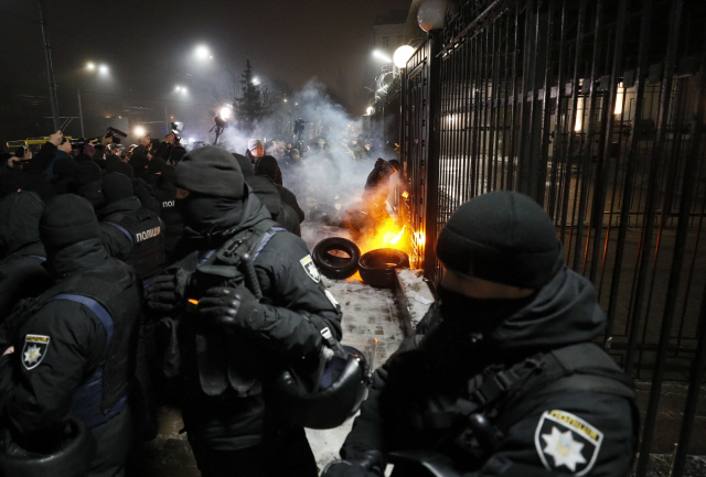 25일(현지시간) 우크라이나 키예프에 위치한 러시아대사관 주변에서 시위대가 러시아의 선박 나포를 비난하며 화염병을 던지자 보안군이 불길을 진압하고 있다. /키예프=로이터연합뉴스