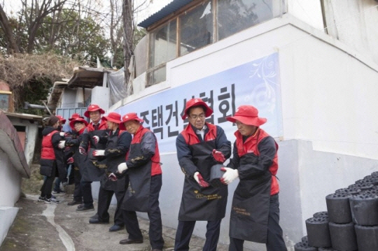 심광일(오른쪽 두번째) 대한주택건설협회 회장이 지난 23일 서울 동작구에서 취약계층에 전달할 연탄을 나르고 있다. 협회는 이날 10만5,000여장의 연탄을 지원했다./사진제공=대한주택건설협회