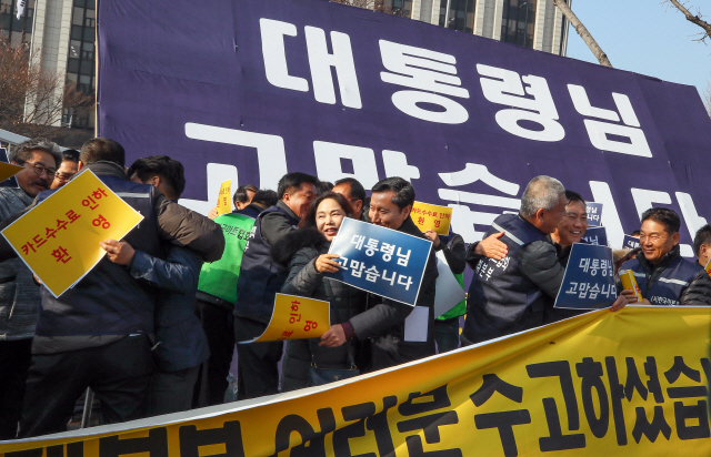 한국중소상인자영업자총연합회, 한국마트협회, 전국가맹점주협의회 등 ‘불공정 카드수수료 차별철폐 전국투쟁본부’의 자영업자들이 26일 세종로 정부서울청사 앞에서 열린 ‘카드수수료 인하 환영 기자회견’에서 서로 포옹하고 기뻐하고 있다./연합뉴스