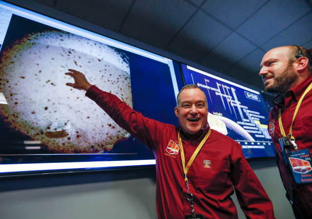 미국 항공우주국(NASA·나사) 제트추진연구소(JPL) 직원들이 26일(현지시간) 화성탐사선 ‘인사이트’가 화성 착륙 직후 처음 보내 온 화성 표면 사진을 가리키며 기뻐하고 있다.  /파사데나=EPA연합뉴스