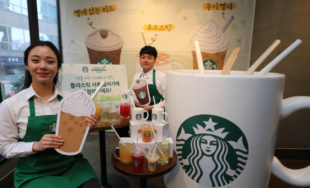 관계자들이 26일 스타벅스 한국프레스센터점에서 종이 빨대와 빨대 없는 컵 리드를 소개하고 있다./연합뉴스