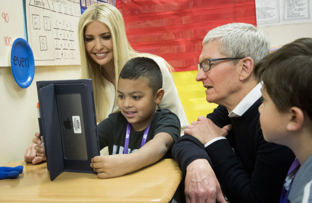 Apple CEO Tim Cook, right, and Ivanka Trump, daughter and advisor to President Donald Trump, talk with first-grader Israel Perez about work he‘s doing on his iPad during a visit to Wilder Elementary School, in Boise Idaho, Tuesday, Nov. 27, 2018. Cooke and Trump visited the school to examine the district’s use of technology. (Katherine Jones/Idaho Statesman via AP)      <저작권자(c) 연합뉴스, 무단 전재-재배포 금지>