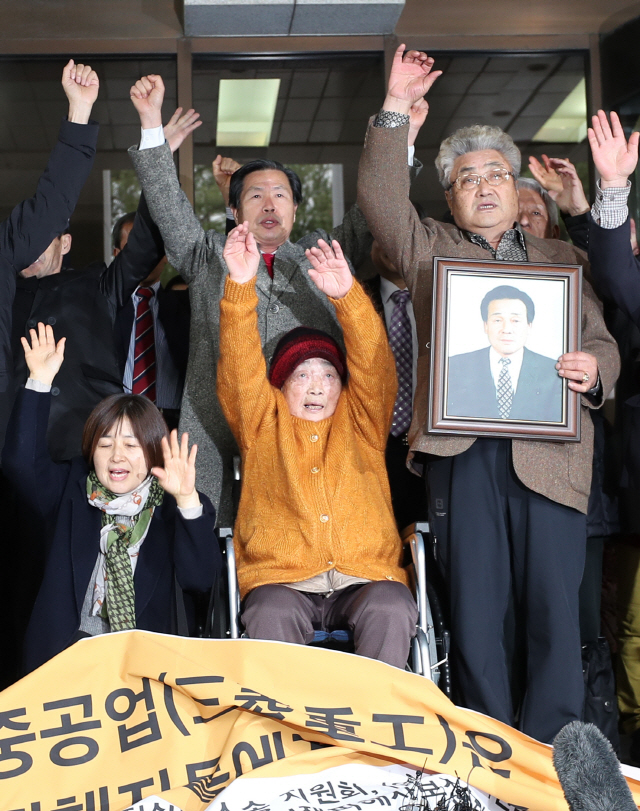 29일 서울 서초동 대법원 대법정 앞에서 일제 강제징용 피해자와 유족들이 미쓰비시중공업 대상 손해배상청구 청구소송 상고심에서 승소한 뒤 만세를 외치고 있다. /연합뉴스