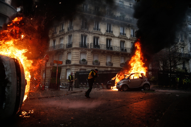 프랑스 정부의 유류세 인상에 반대하는 ‘노란 조끼’ 시위대가 1일(현지시간) 파리 중심가에 설치된 바리케이트에 불을 지르며 시위하고 있다. /파리=AFP연합뉴스