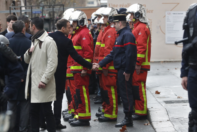 에마뉘엘 마크롱 프랑스 대통령이 2일(현지시간) 파리 중심가에서 벌어진 ‘노란 조끼’ 시위대의 폭력 사태 진화를 위해 투입된 소방관들과 악수를 나누고 있다. /파리=AP연합뉴스